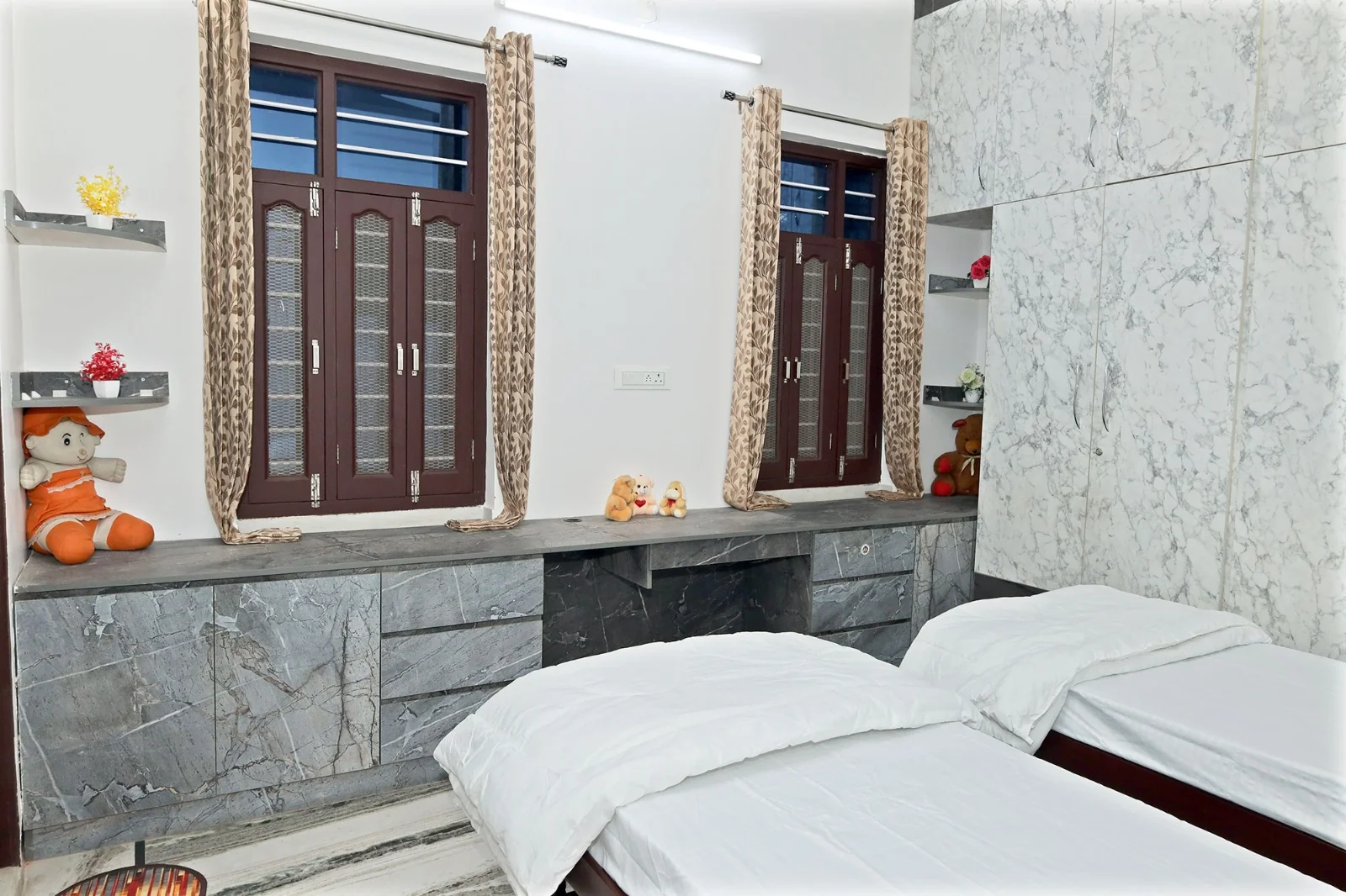 Twin bedroom with wardrobe and windows at Meeraavi Home Stay, Udaipur