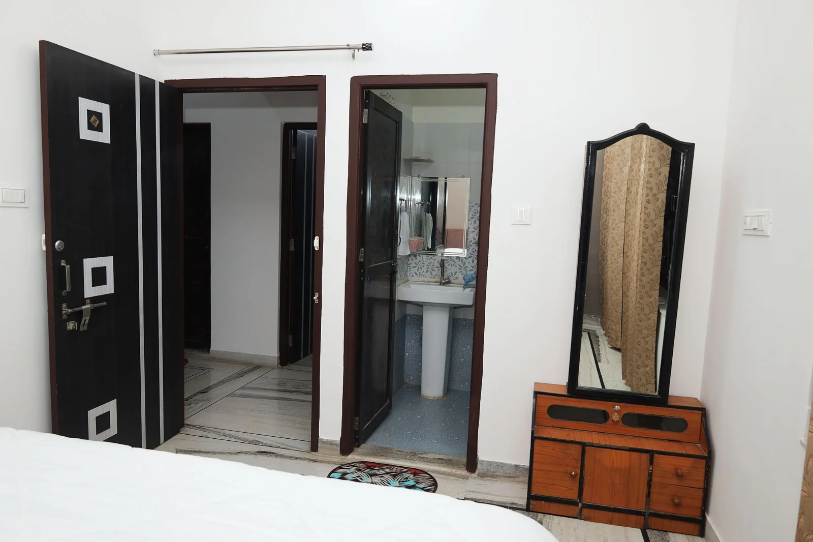 Bedroom dressing passage with mirror and doors at Meeraavi Home Stay, Udaipur