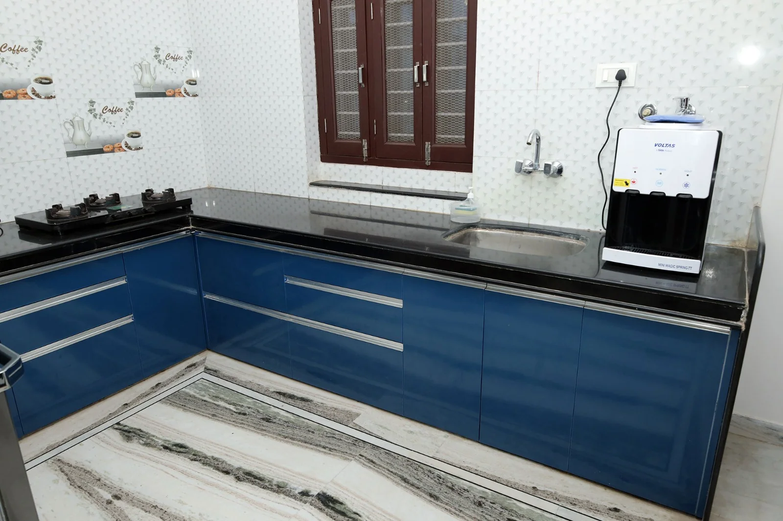 Modular blue kitchen with gas stove at Meeraavi Home Stay, Udaipur